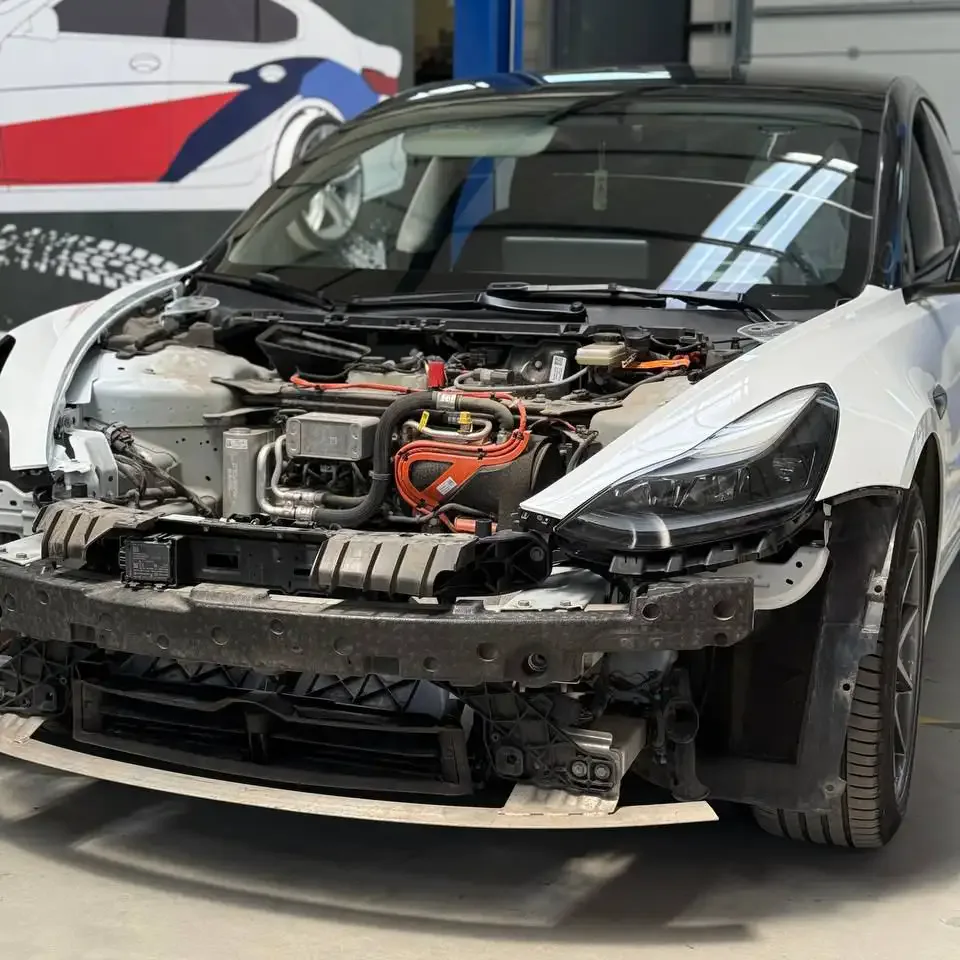 Tesla Model 3 с разобранной передней частью в мастерской Bimmer Workshop.