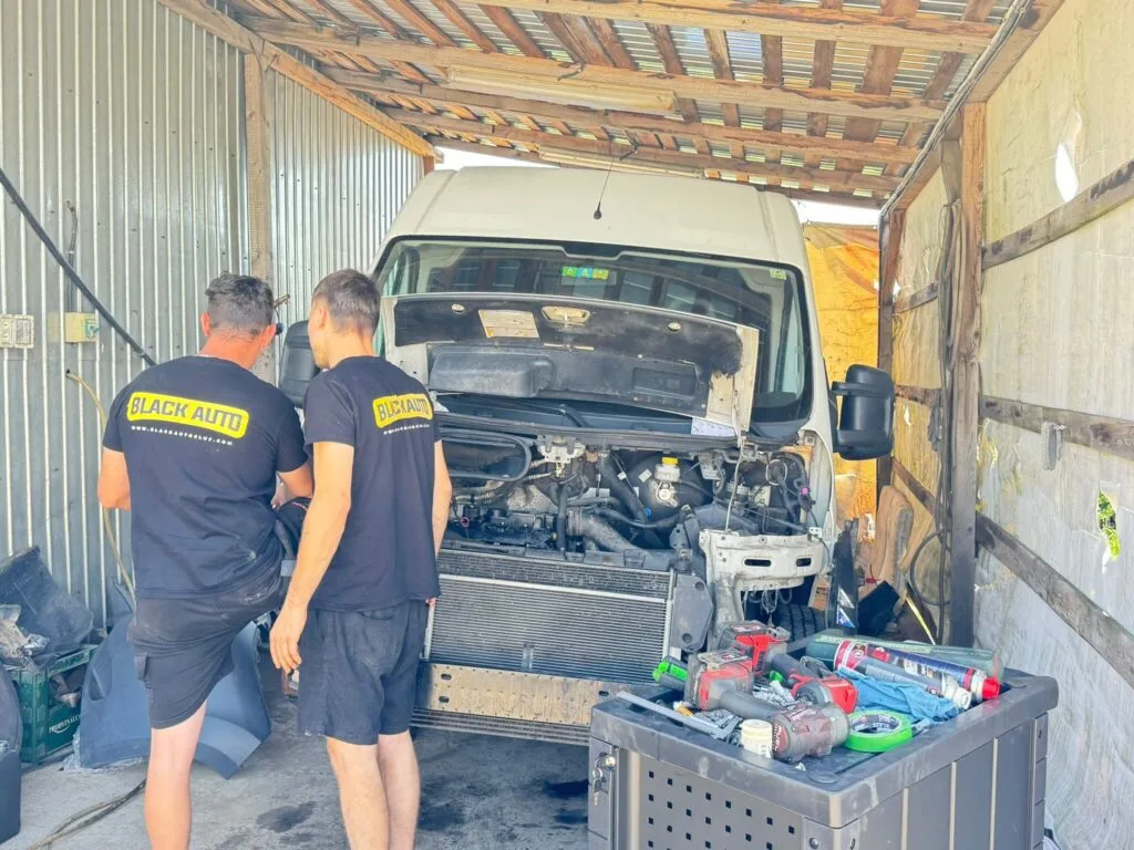 Мастера Black Auto Service работают в своём ремонтном боксе.