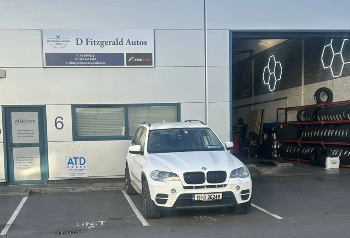 Фасад мастерской D Fitzgerald Autos в Дублине с вывеской и открытым ремонтным боксом.