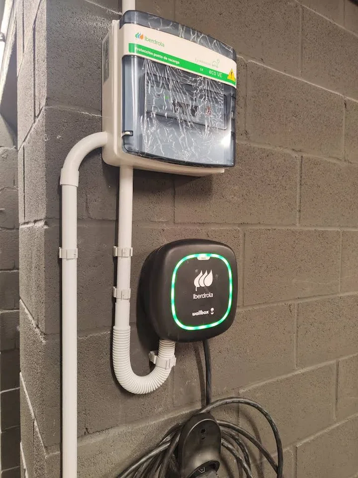 Установленная зарядная станция Wallbox на стене здания; фото из галереи Ritest в Мадриде, декабрь 2025 года.