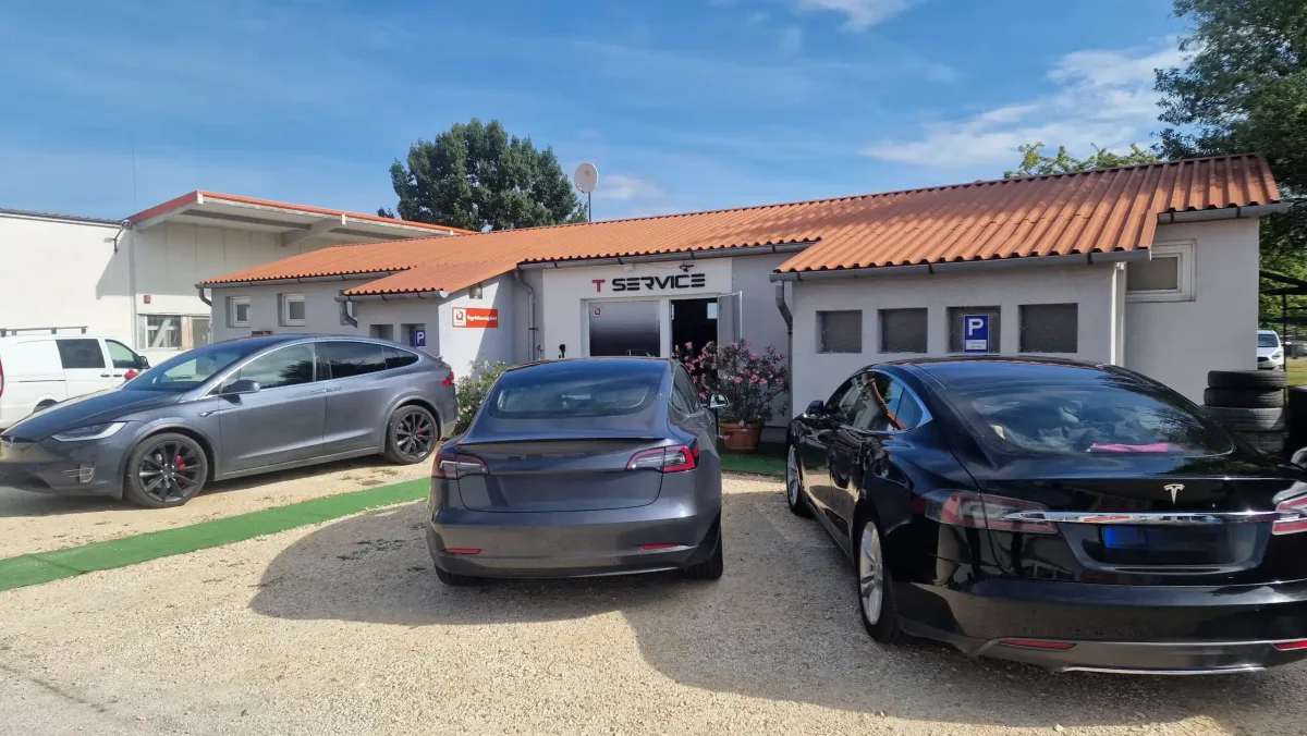 Фасад мастерской T-Service в Дьёмрё с несколькими автомобилями Tesla перед входом.