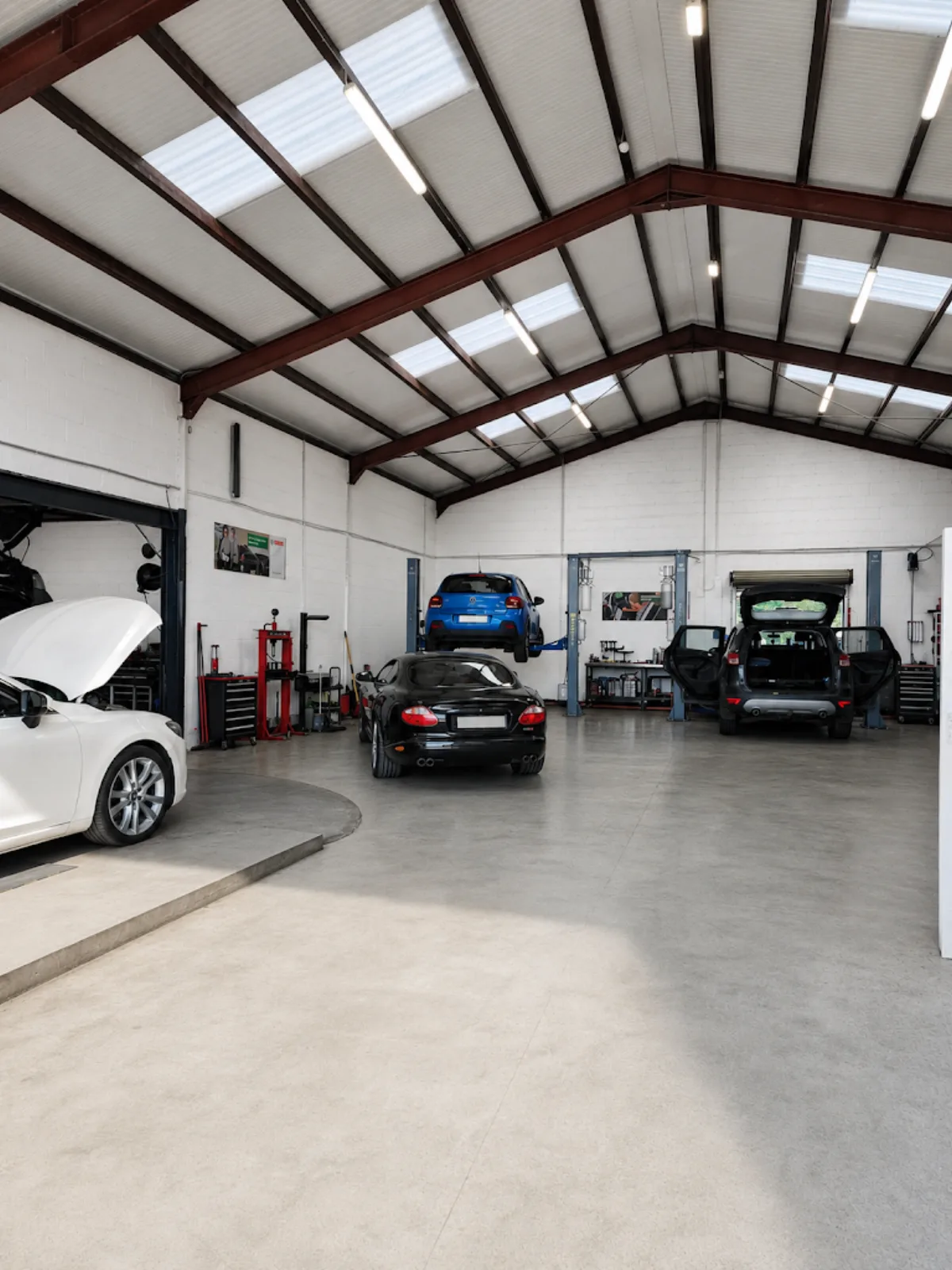 Ремонтный цех TD Garages в Килкенни с несколькими автомобилями и подъёмником.