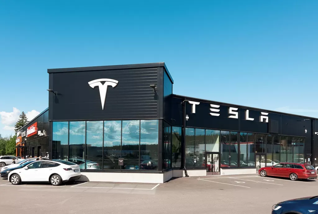 Exterior of the Tesla Service Center in Raisio, with Tesla vehicles parked outside.
