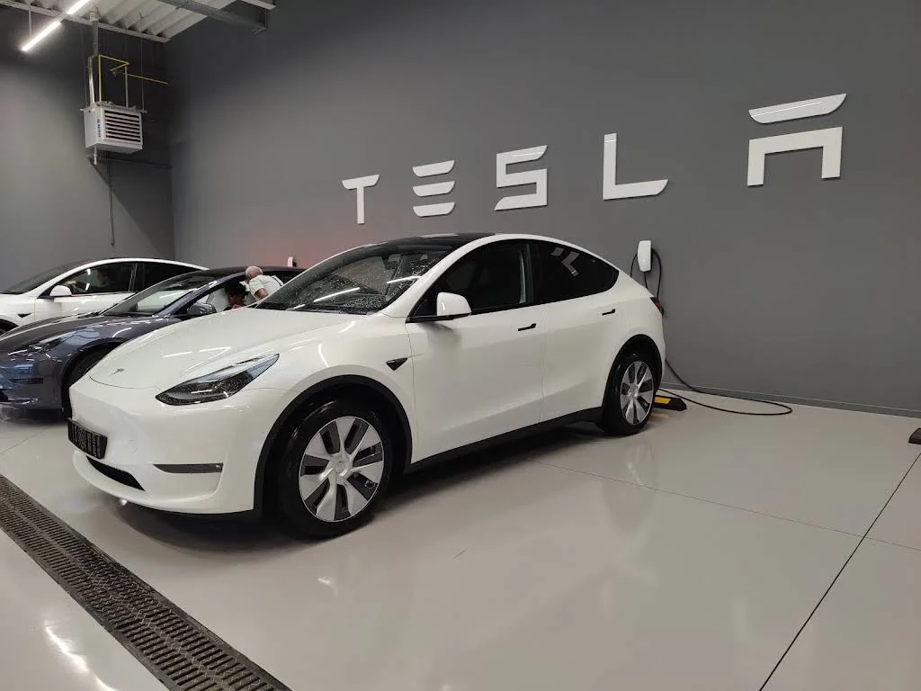 Клиентская зона Tesla Center Brussels Drogenbos: Model Y стоит в выставочном помещении с логотипом Tesla; фото августа 2023 года.