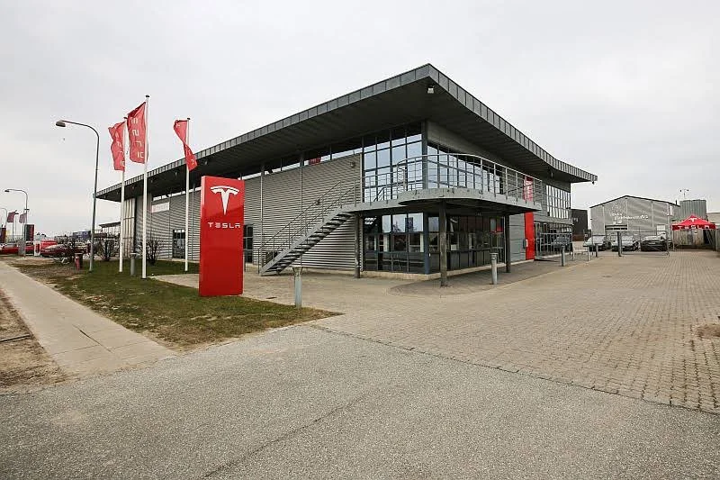 Внешний вид официального сервисного центра Tesla в Каструпе; здание и вывеска Tesla, фото декабря 2024 года.