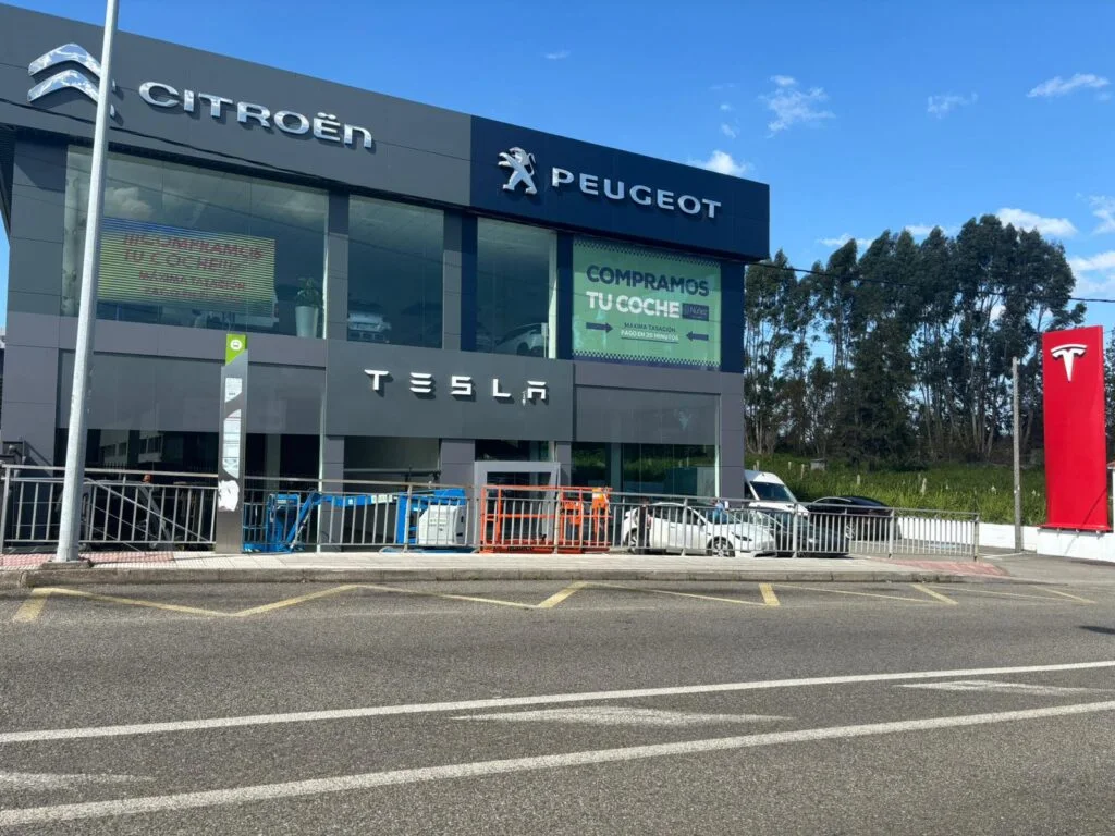 Фасад филиала Tesla на Estrada de Camposancos в Виго с установленной вывеской и помещением, готовящимся к открытию.