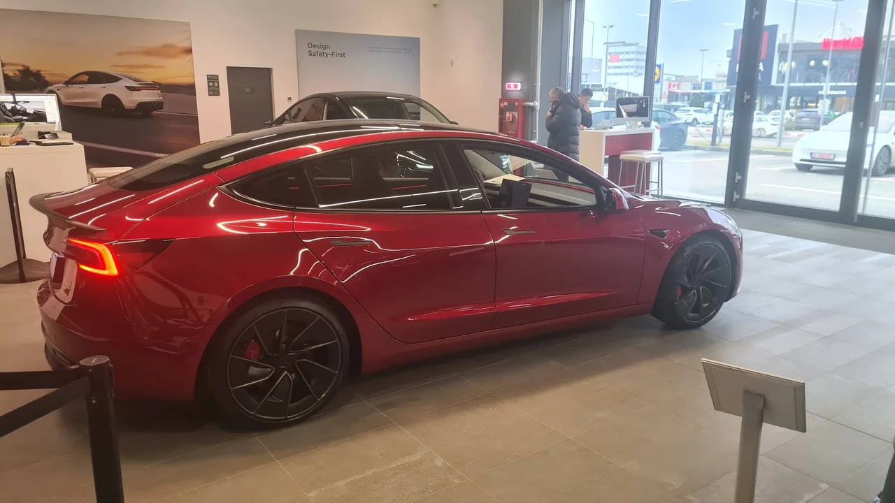 Красная Tesla в зале Tesla Center București Pipera по адресу Șoseaua București Nord 15–23, Волунтари.