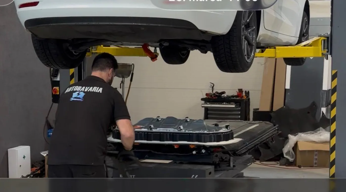 Механик AUTOBAVARIA работает с тяговой батареей Tesla в мастерской Бадина.