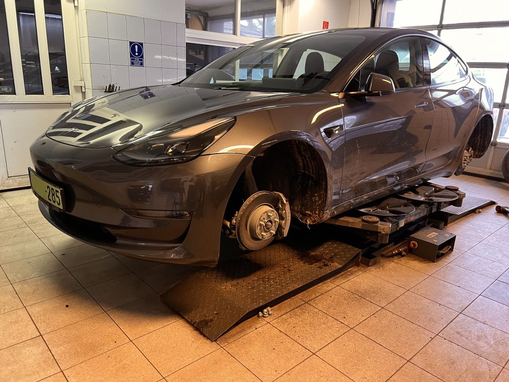 Tesla Model 3 без колёс на подъёмнике в мастерской TESLA17.