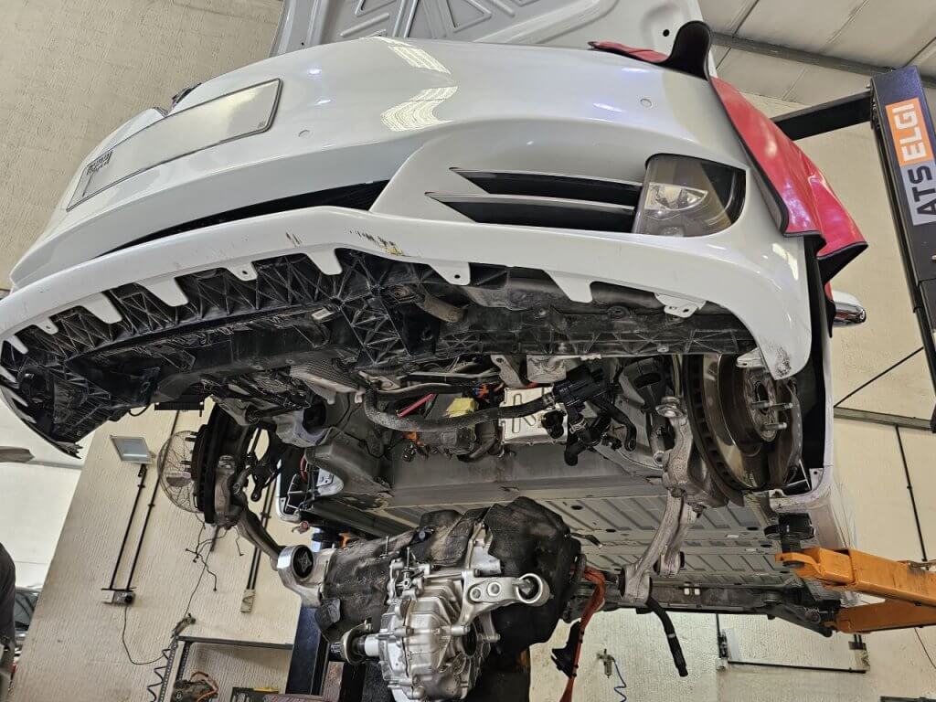 A Tesla on a lift with its drive unit removed.