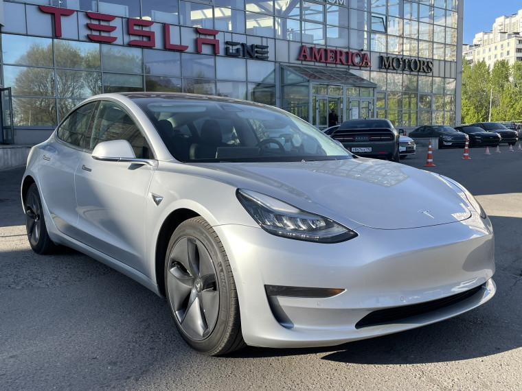 Tesla на площадке America Motors; на фасаде видны вывески America Motors и Tesla.