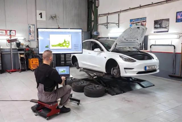 Technik Torera pracuje na voze Tesla Model 3 v pražské dílně.