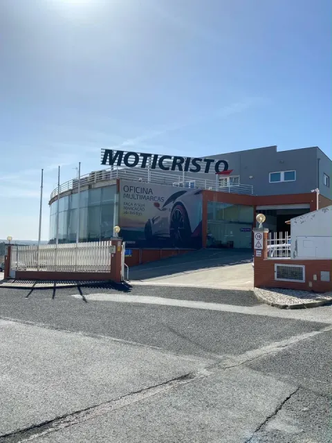 Exterior da Moticristo Oficina Automóvel em Mafra, com o letreiro Moticristo visível no edifício.