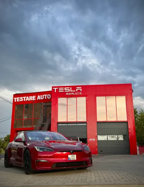 Fațada Tesla Motors Moldova Tesla Service din Vatra, cu firmele TESLA SERVICE și TESTARE AUTO; în față se află un Tesla Model S. Fotografie din august 2026.
