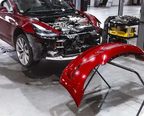 Červená Tesla počas karosárskej opravy v Autocentre Zachar.