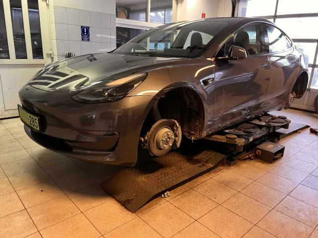 Tesla Model 3 kerekek nélkül, a TESLA17 műhelyében emelőn.