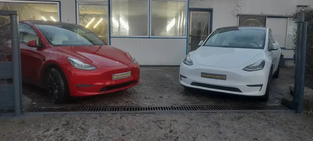 Две Tesla Model 3 с табели Tesla Royal Service пред сградата на сервиза в София; снимка от януари 2024 г.