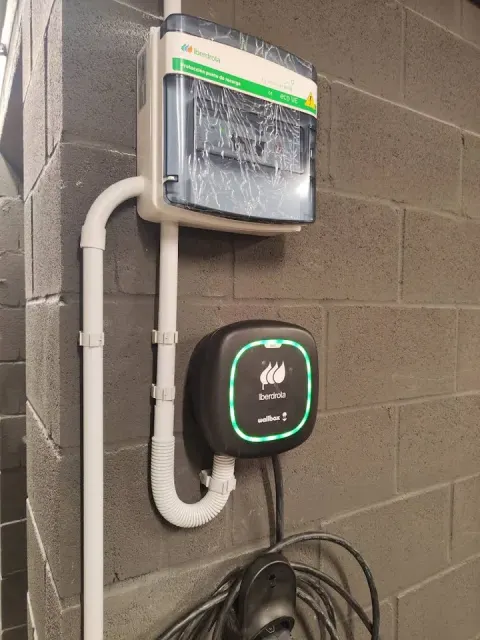 Cargador Wallbox instalado en la pared de un edificio; fotografía de la galería de Ritest en Madrid, de diciembre de 2025.