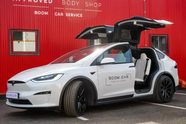 Tesla Model X în fața Boom Car Service, lângă firma Tesla Approved Body Shop.