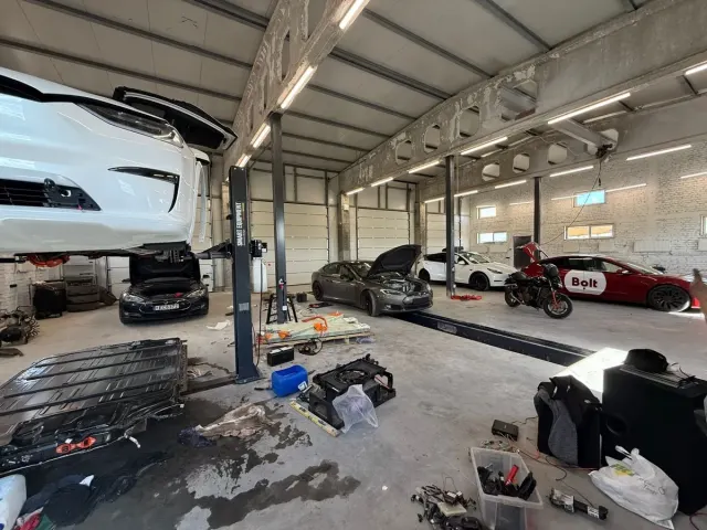 EVS Vilnius remonto patalpos, priekyje keli Tesla automobiliai ir atvertas akumuliatorius.