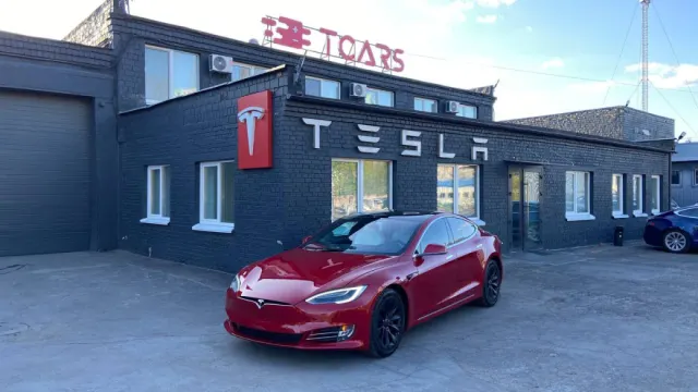 Будівля сервісу TCARS у Києві та Tesla перед входом.