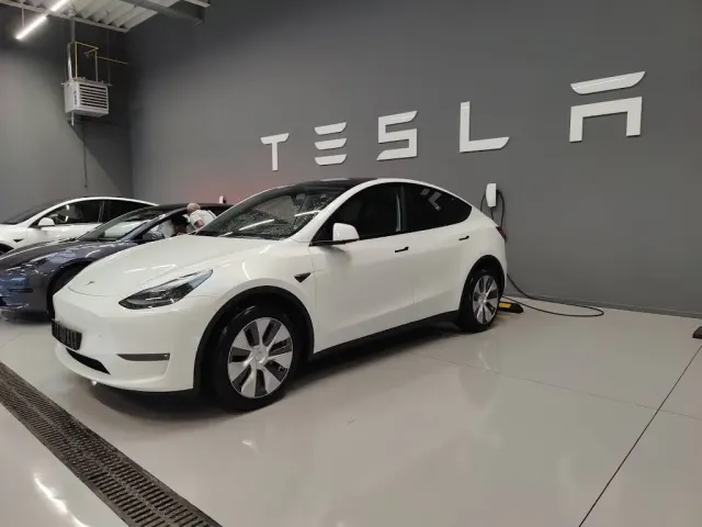 Kundenbereich im Tesla Center Brussels Drogenbos: ein Model Y im Ausstellungsraum neben einem Tesla-Logo. Foto aufgenommen im August 2023.