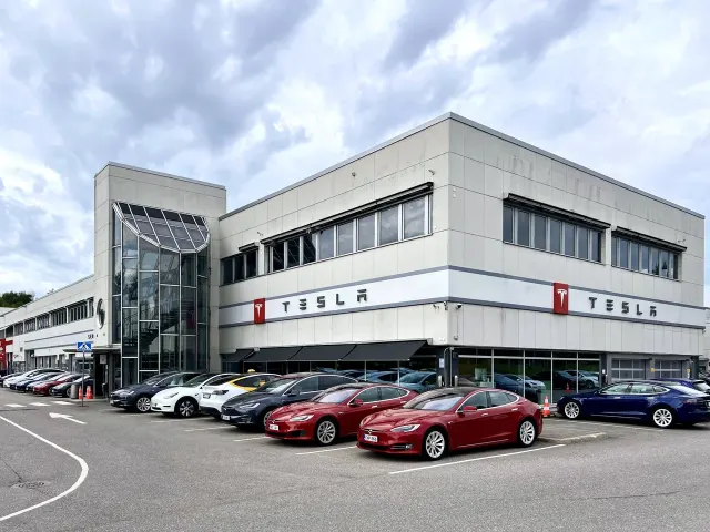 Exteriör av Tesla Center Helsinki–Vantaa med TESLA-skyltar och parkerade bilar vid Vetokuja 1. Fotot togs i juli 2024.